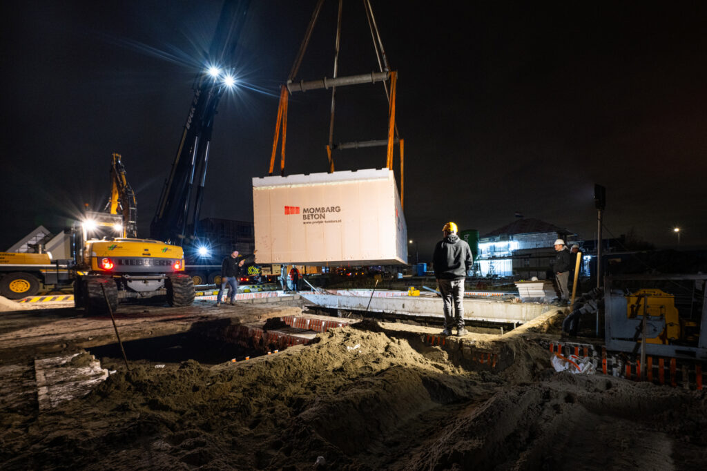 Prefab kelderbak in het uitgegraven gat laten zakken